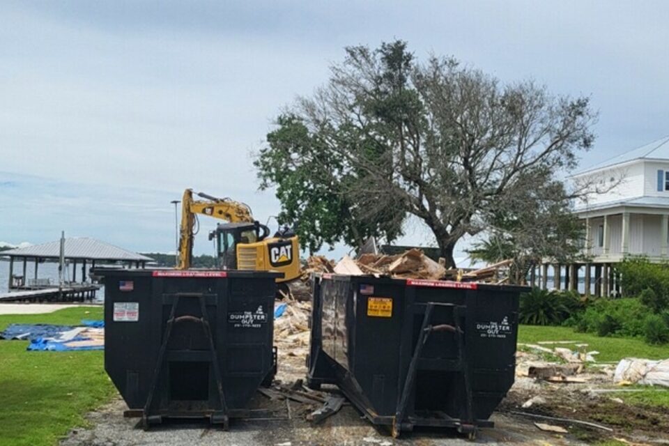Two containers on a waterfront lot during a tear-out
